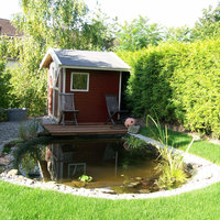 Geräteschuppen im Garten neben einem Teich