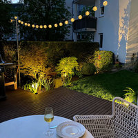 Terrasse aus Holz mit Stühlen und Tisch im Garten